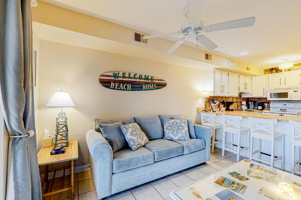 a living room with a blue couch and a kitchen at Jamaica IV 209 in Ocean City