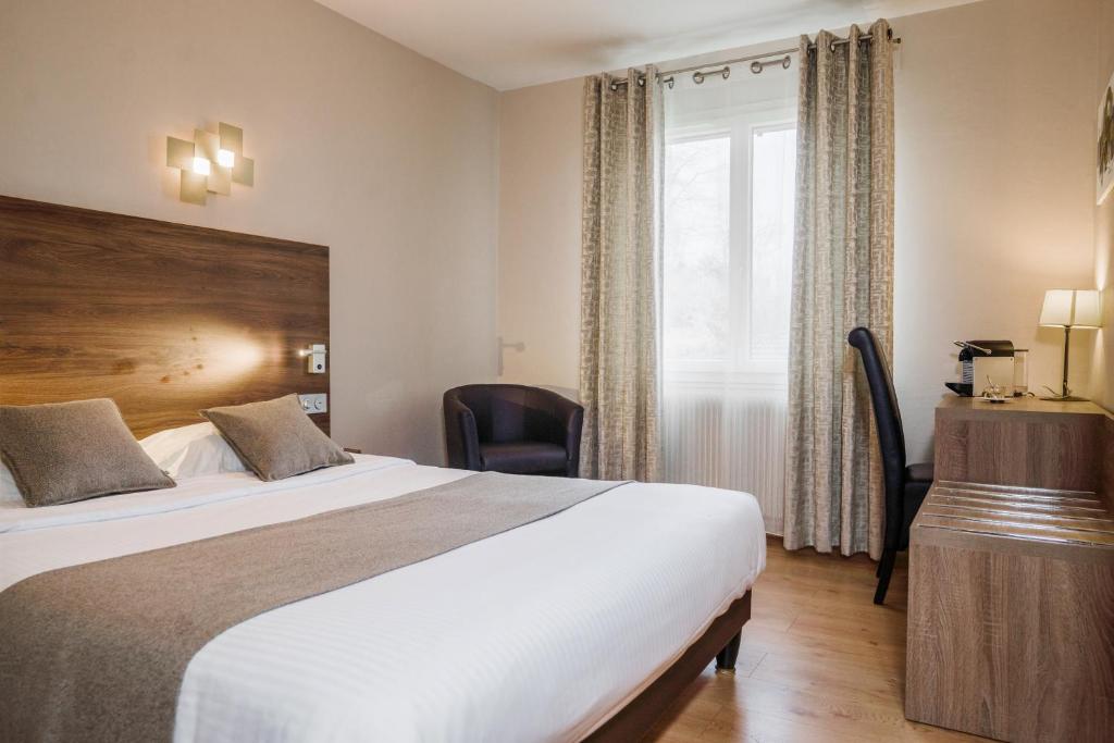 Postel nebo postele na pokoji v ubytování Logis Hotel Le Petit Casset