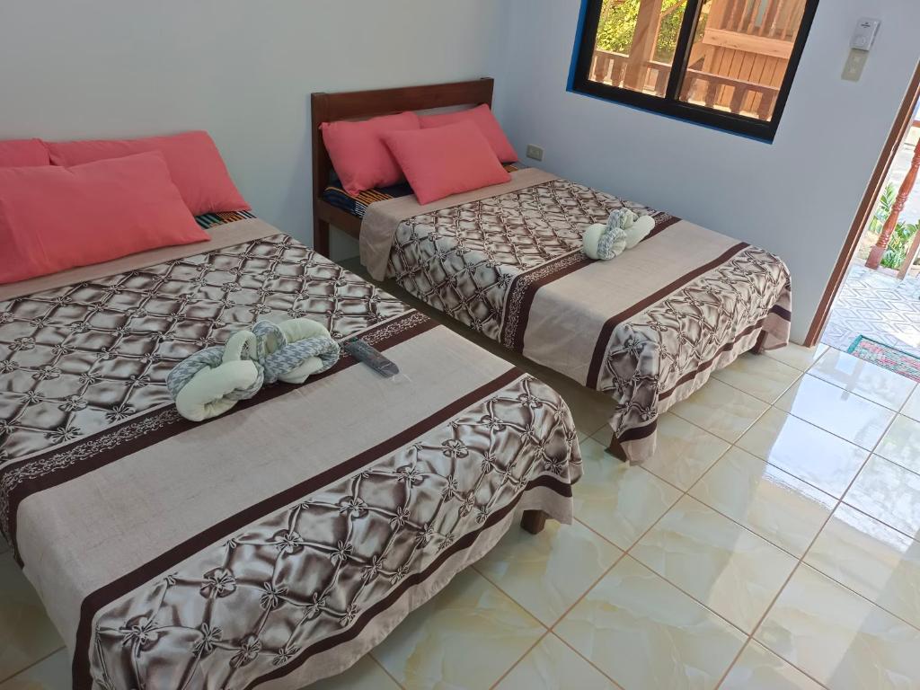 Camera con 2 letti e pavimento piastrellato. di Hadefe Cottages a El Nido