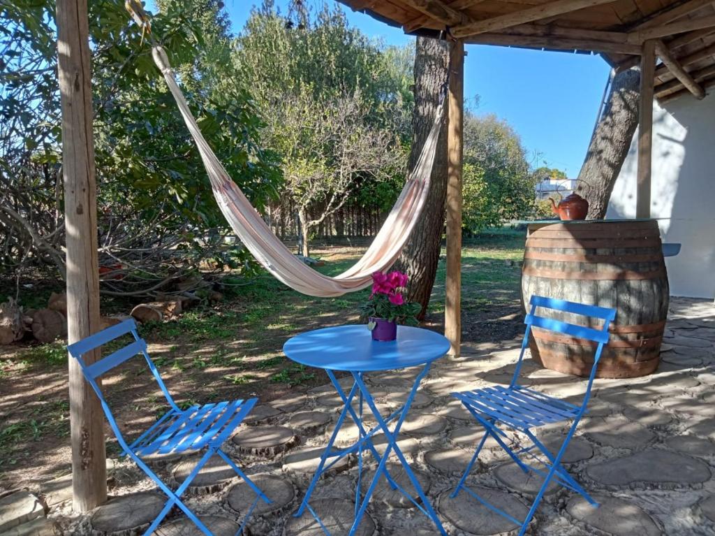 una mesa, 2 sillas y una hamaca en el patio en La Bodega de Villa Bella, en Espartinas