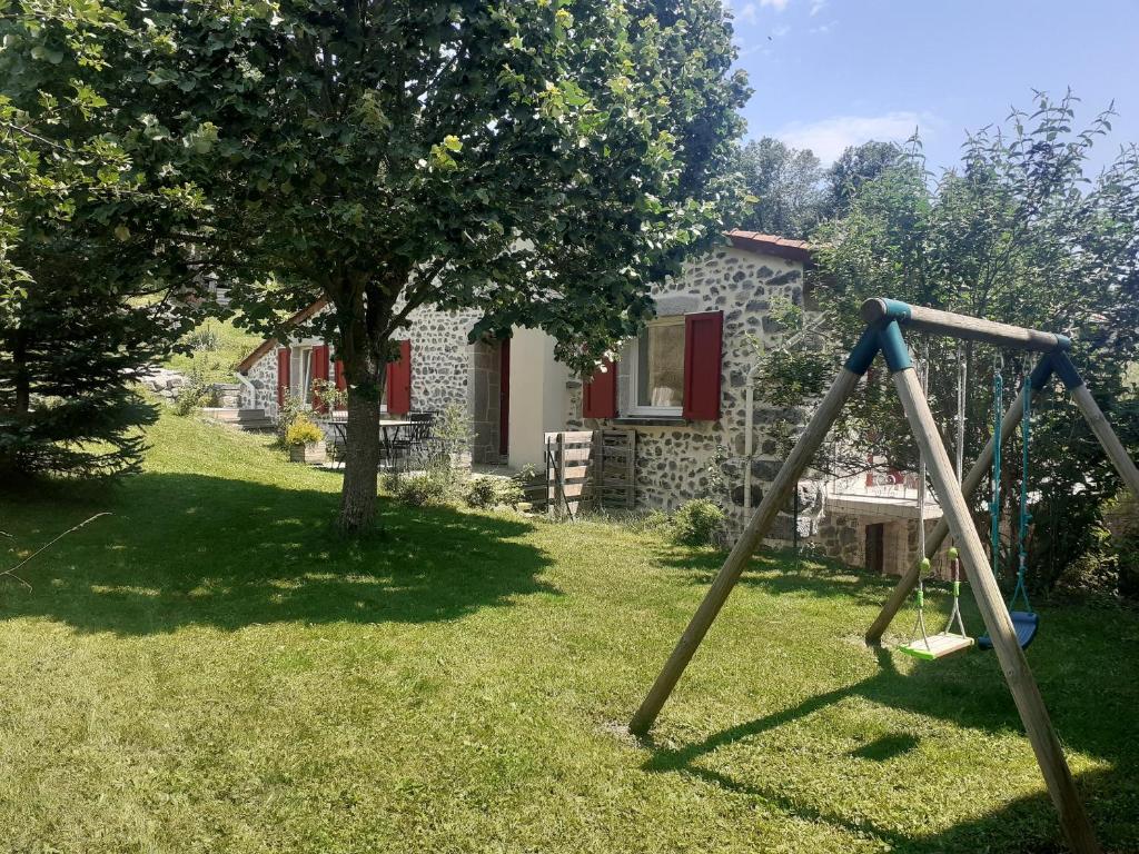 a swing set in a yard with a house at la siestou in Le Monteil