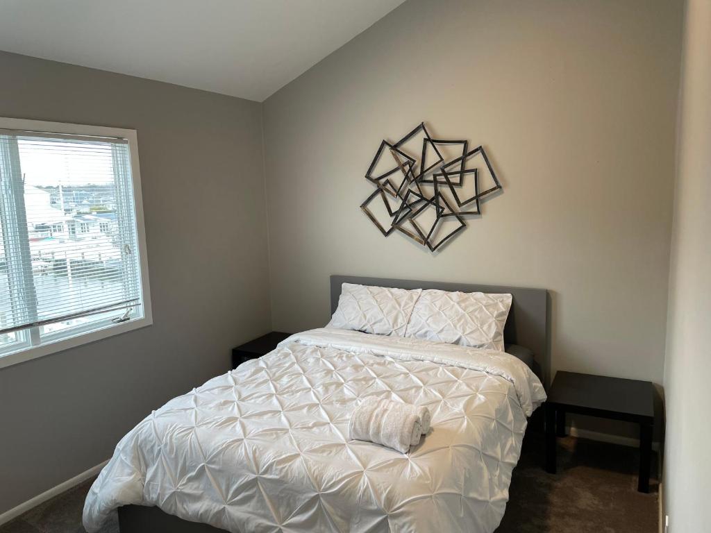 a bedroom with a white bed and a window at Waterfront Home in Brick with Swimming Pool Access in Shore Acres