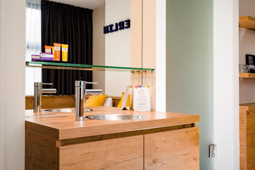 a bathroom with a sink in a wooden counter at Citiez Hotel Amsterdam in Amsterdam