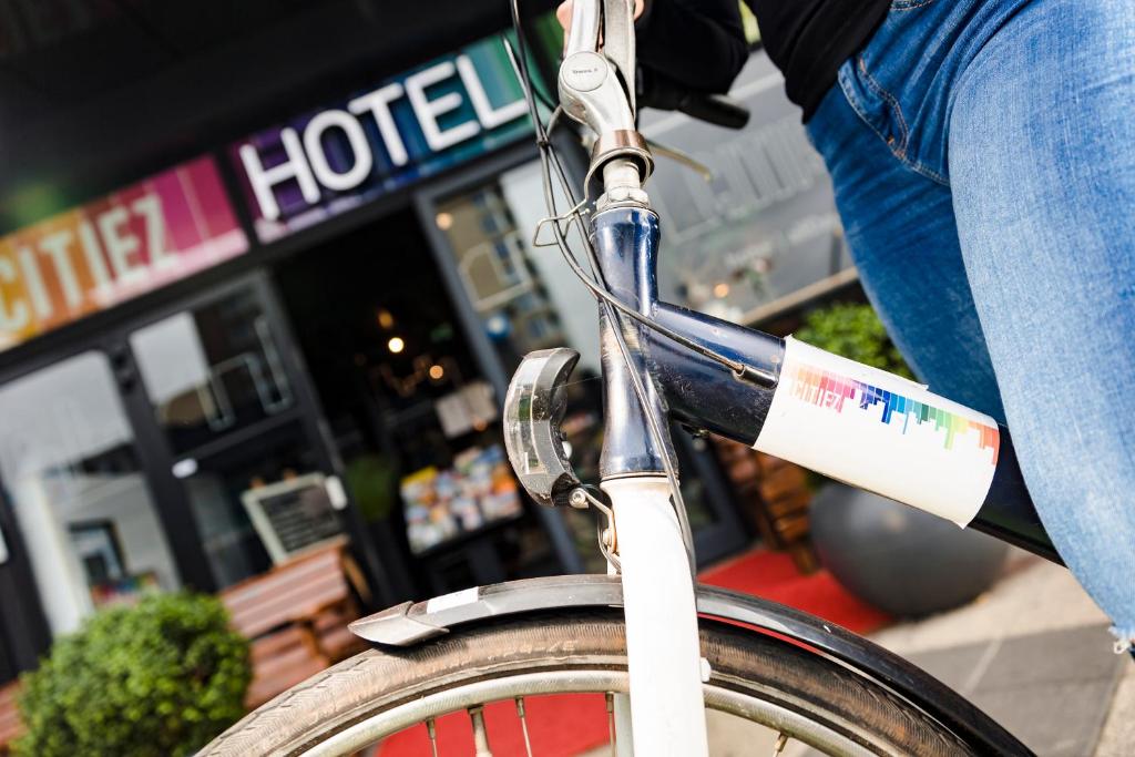 a person is riding a bike in front of a hotel at Citiez Hotel Amsterdam in Amsterdam