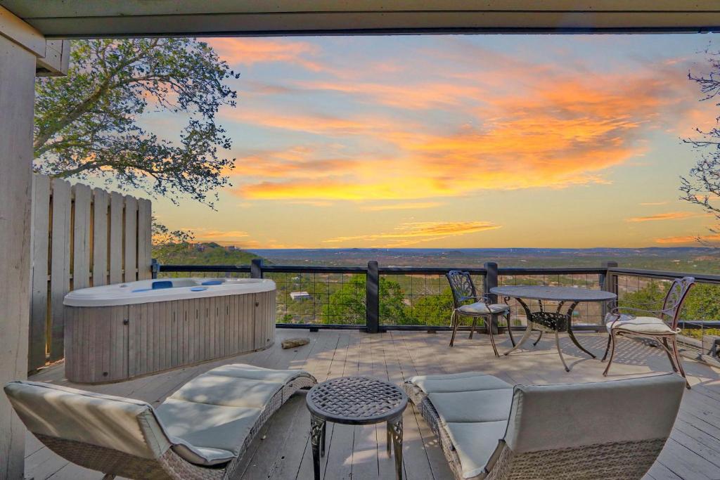 Un patio con jacuzzi y una mesa y sillas. en Sunset Villa, en Wimberley