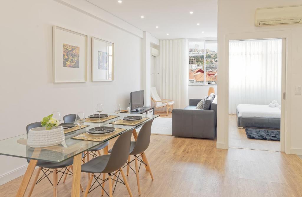 een eetkamer en een woonkamer met een tafel en stoelen bij Luxury Prime Batalha Apartments in Porto