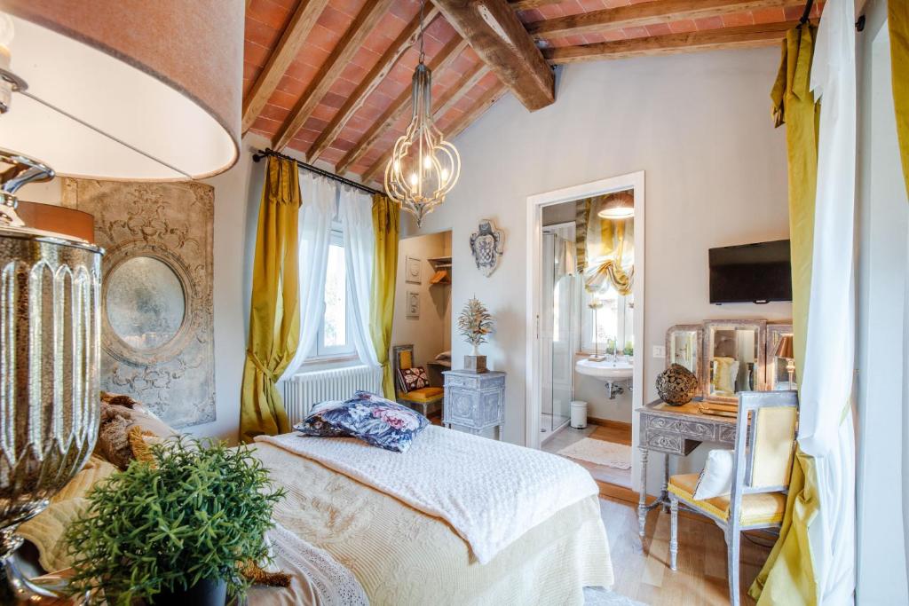 une chambre avec un grand lit et une salle de bain dans l'établissement Villa Gianna, the Secret Interior Designer's Private Retreat with Pool, à San Piero in Campo
