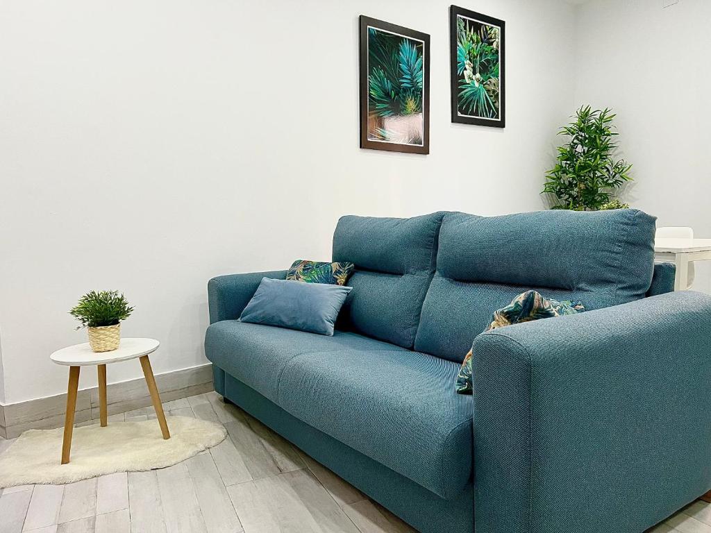 niebieską kanapę w salonie ze stołem w obiekcie Apartamento Centro San Diego w mieście Sanlúcar de Barrameda