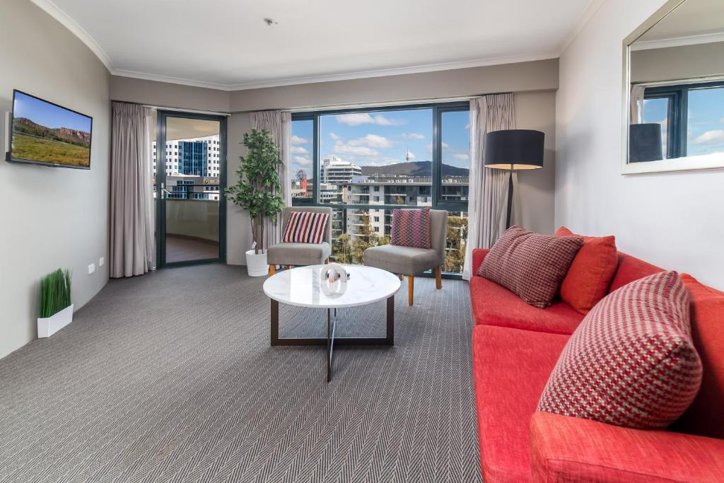 sala de estar con sofá rojo y mesa en 2BR 2Bath L8 Executive Apartment, in City Centre en Canberra