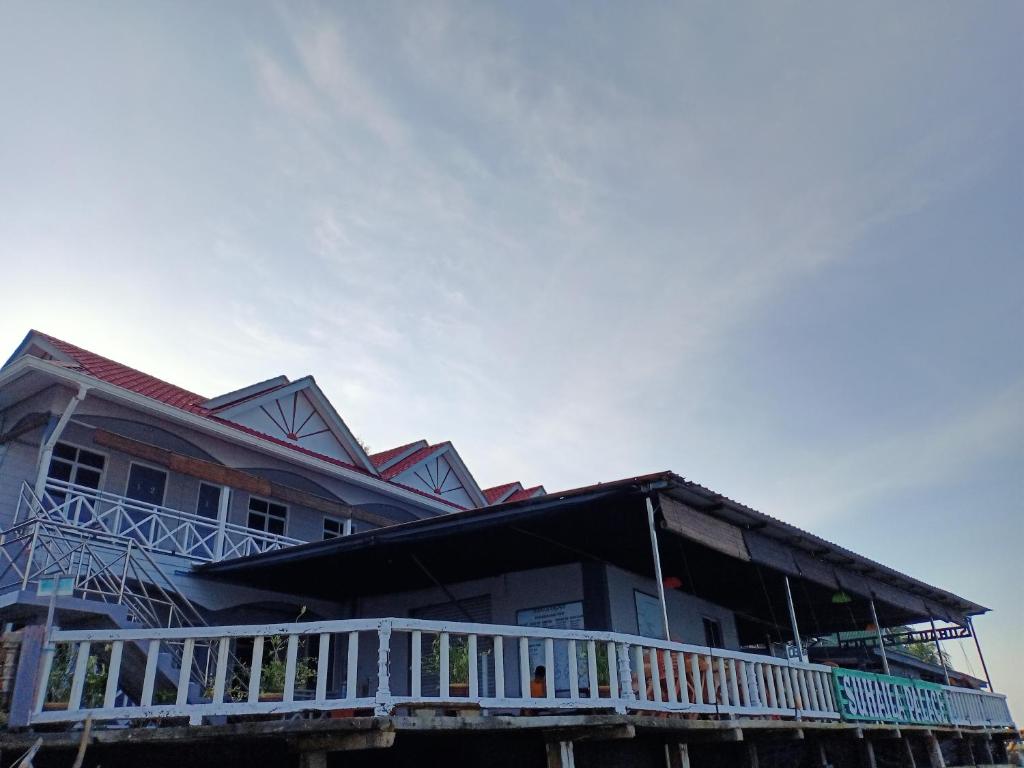 a house with a white balcony on the side of it at Suhaila Palace in Perhentian Islands