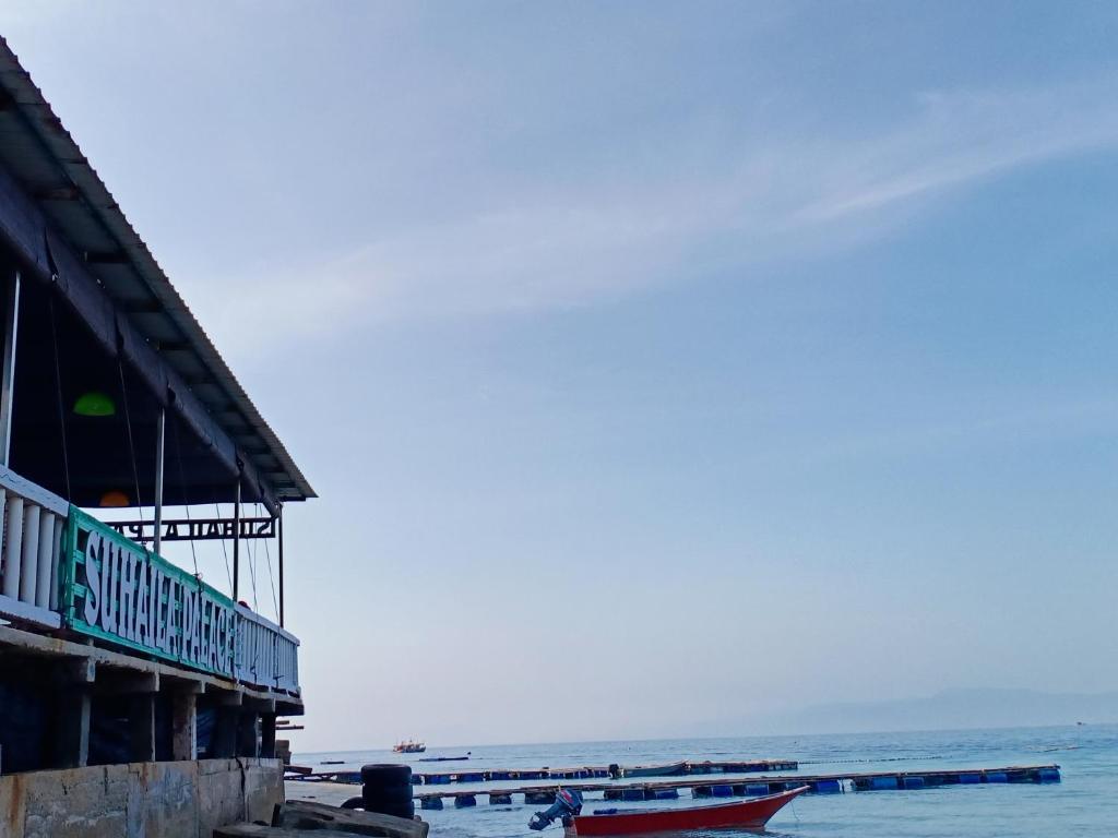 a building next to the ocean with boats in the water at Suhaila Palace in Perhentian Islands