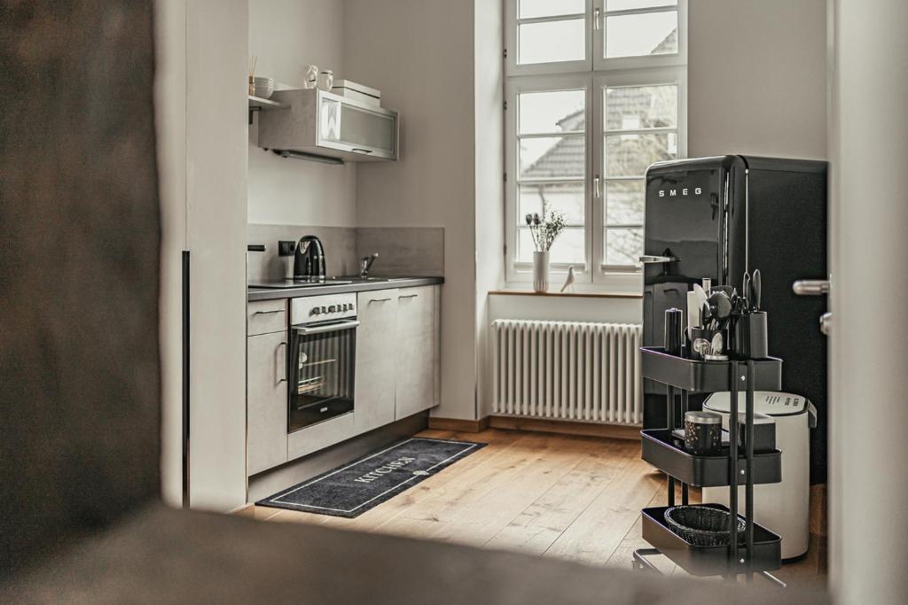 a kitchen with a black refrigerator and a wooden floor at Kremers Freiräume in Arnsberg