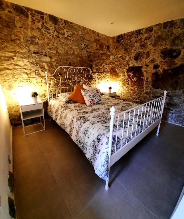 una camera con un letto in una parete in pietra di BELLE VUE Mountain Home a Kalopanayiotis