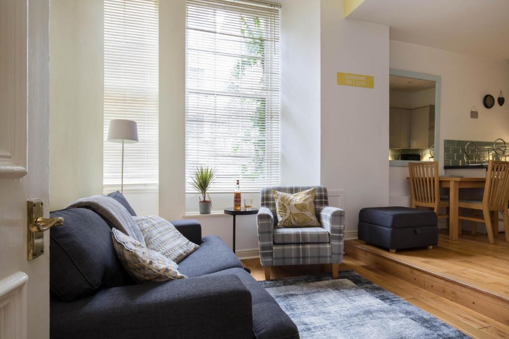 a living room with a blue couch and a table at Sunshine On Leith Apartment in Edinburgh