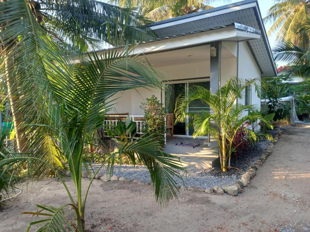 una casa con palmeras delante en bungalow independant, en Srithanu