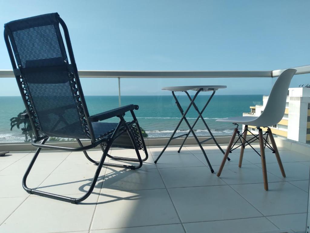 Smart Home with ocean view top floor في تونسوبا: كرسيين وطاولة على شرفة مع المحيط