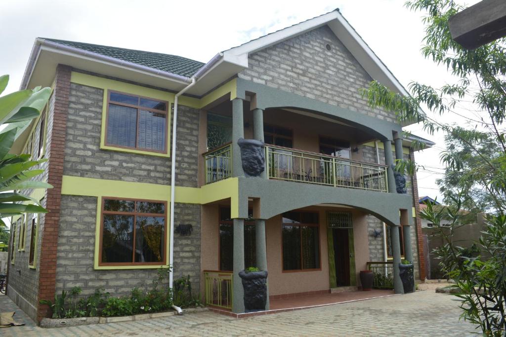 a house with a balcony in front of it at Korona Villa Lodge in Arusha