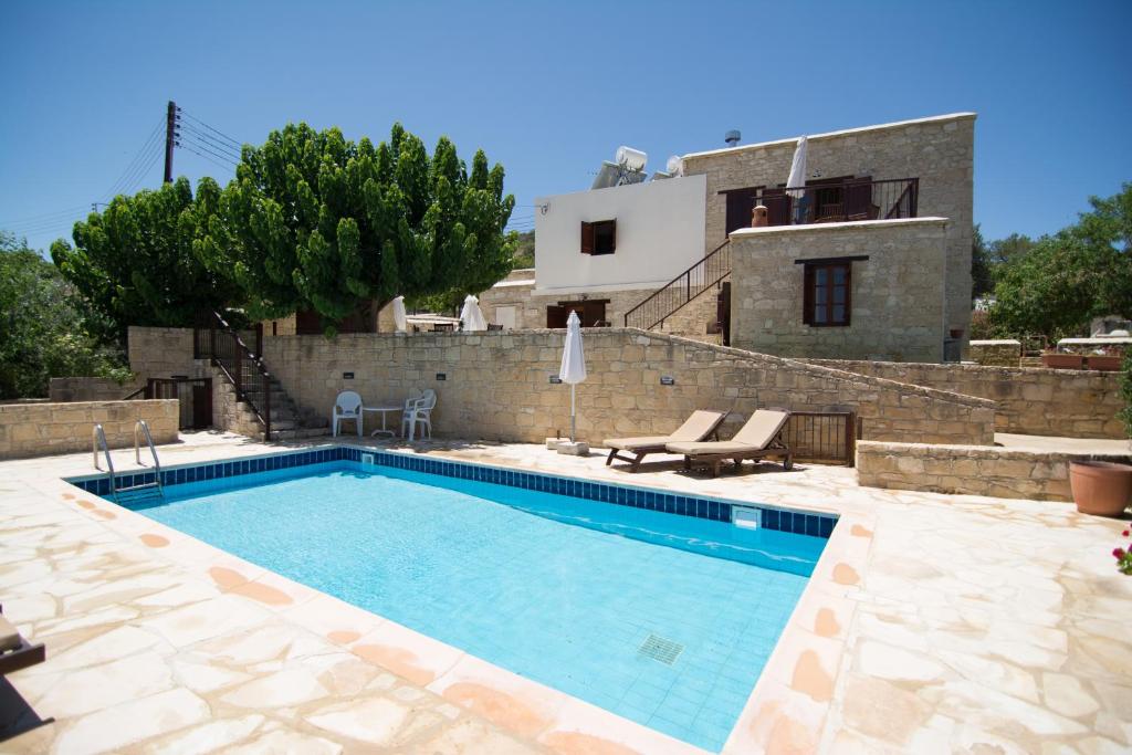 a villa with a swimming pool and a house at Elpida's Stone Houses in Goudhi