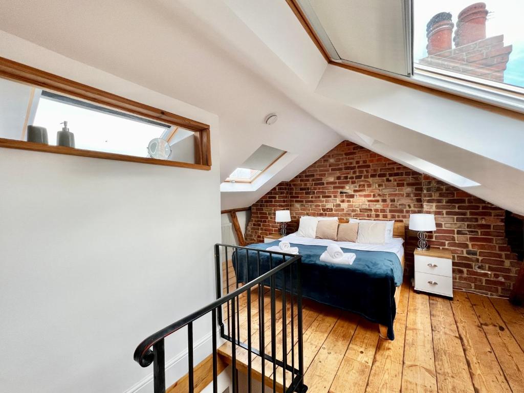 a attic bedroom with a bed and a brick wall at Cecil Street in Lincoln