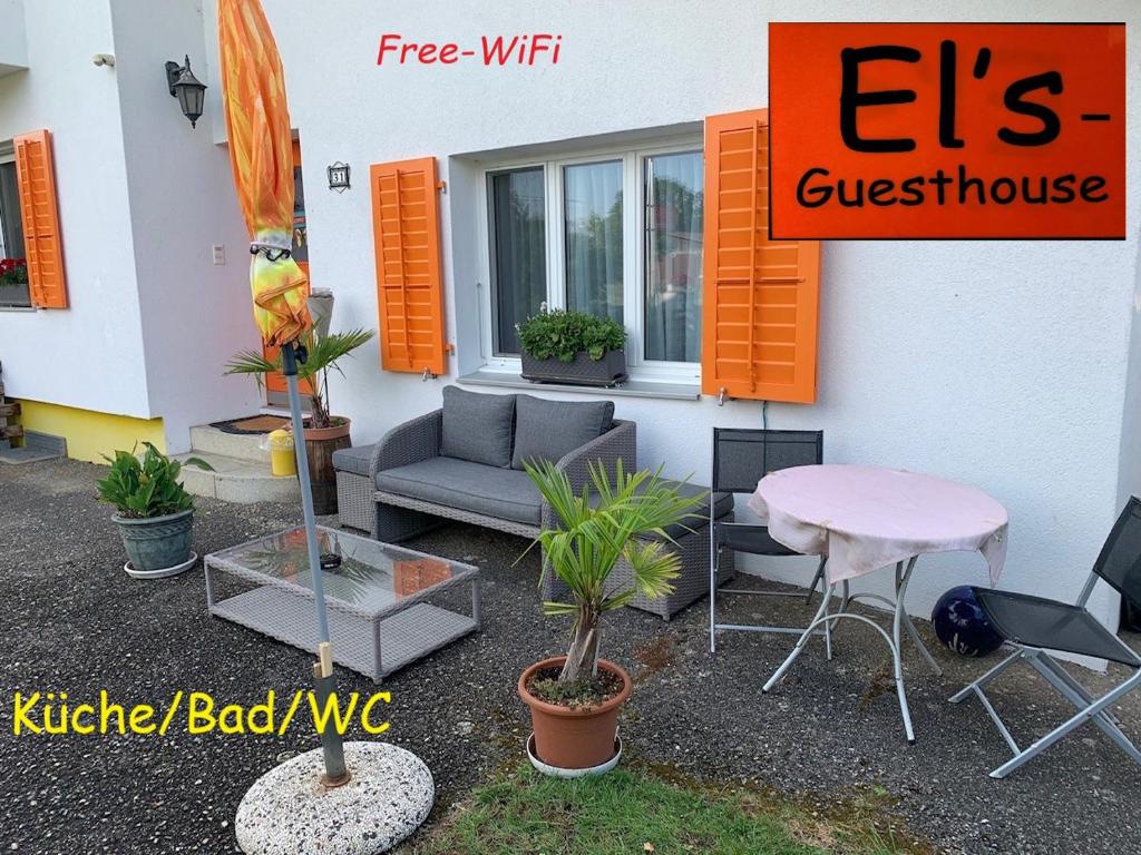 un edificio con patio arredato con tavolo e sedie di El's Guesthouse a Bannwil