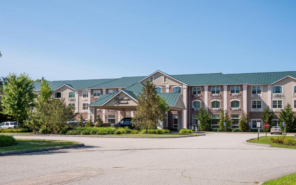 a large apartment building with a parking lot at Bellissimo Grande Hotel in North Stonington