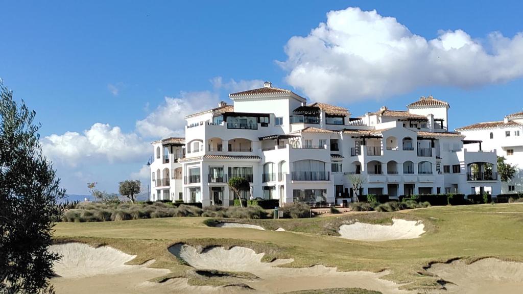una gran casa blanca en un campo de golf en Calle Atlantico 74 3B Penthouse, en Sucina