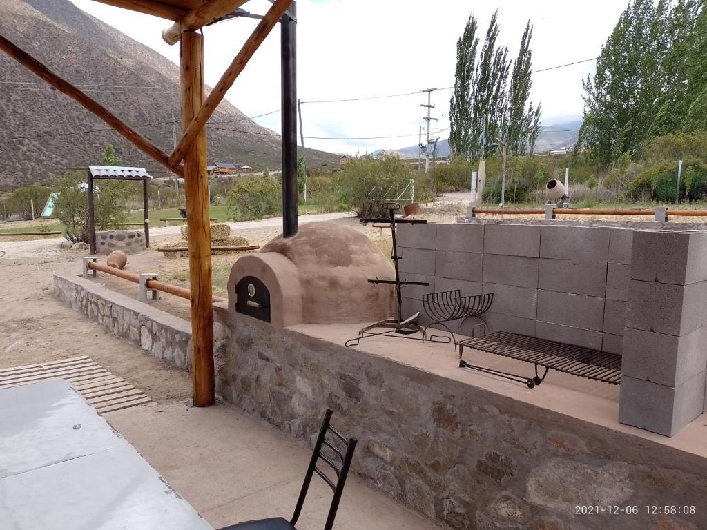 a patio with a pizza oven with a table and chairs at Cabañas Comarca de la Quebrada in Potrerillos