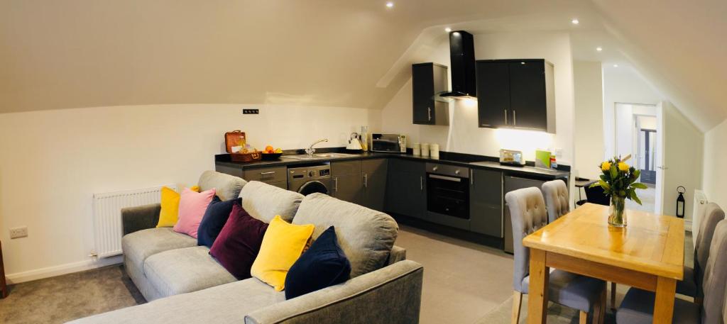 ein Wohnzimmer mit Couch und Küche in der Unterkunft Kettlesing Cottage, Harrogate in Harrogate