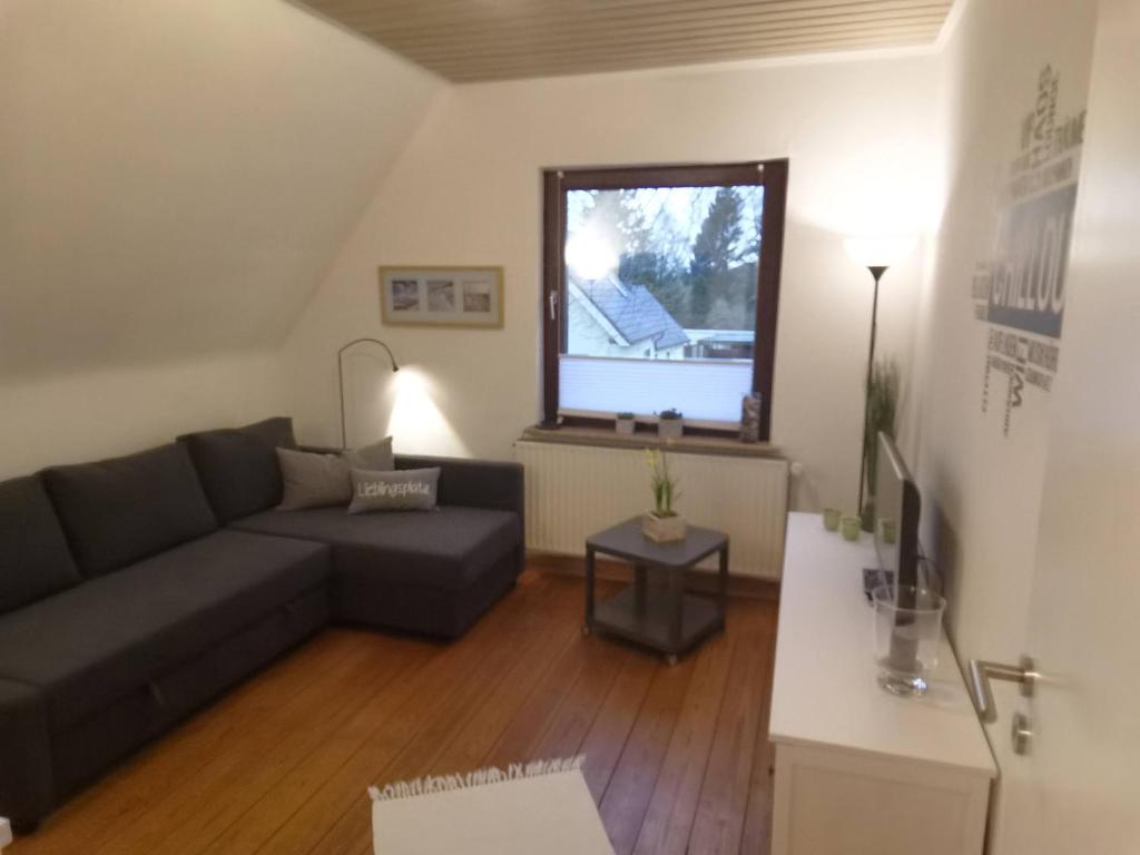 sala de estar con sofá y TV en Ferienwohnung-Haus Holly, en Uetersen