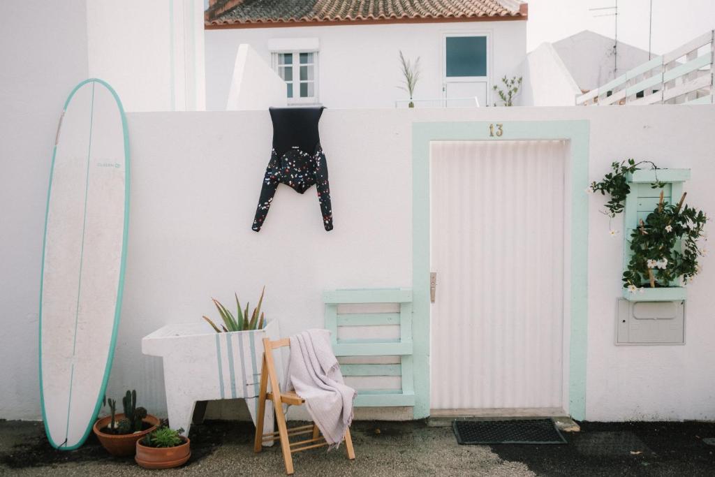 a white wall with a door and a surfboard at La casita 13 in Ferrel