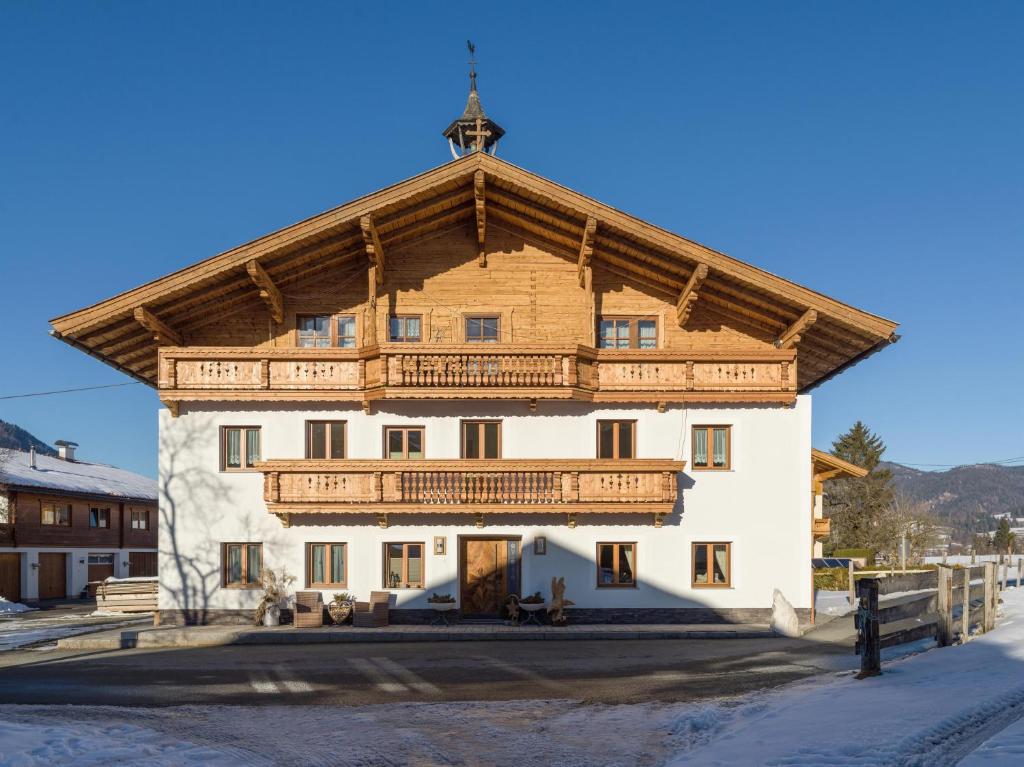 ein großes Gebäude mit einem Holzdach in der Unterkunft Ferienwohnung Döllerer in Kössen