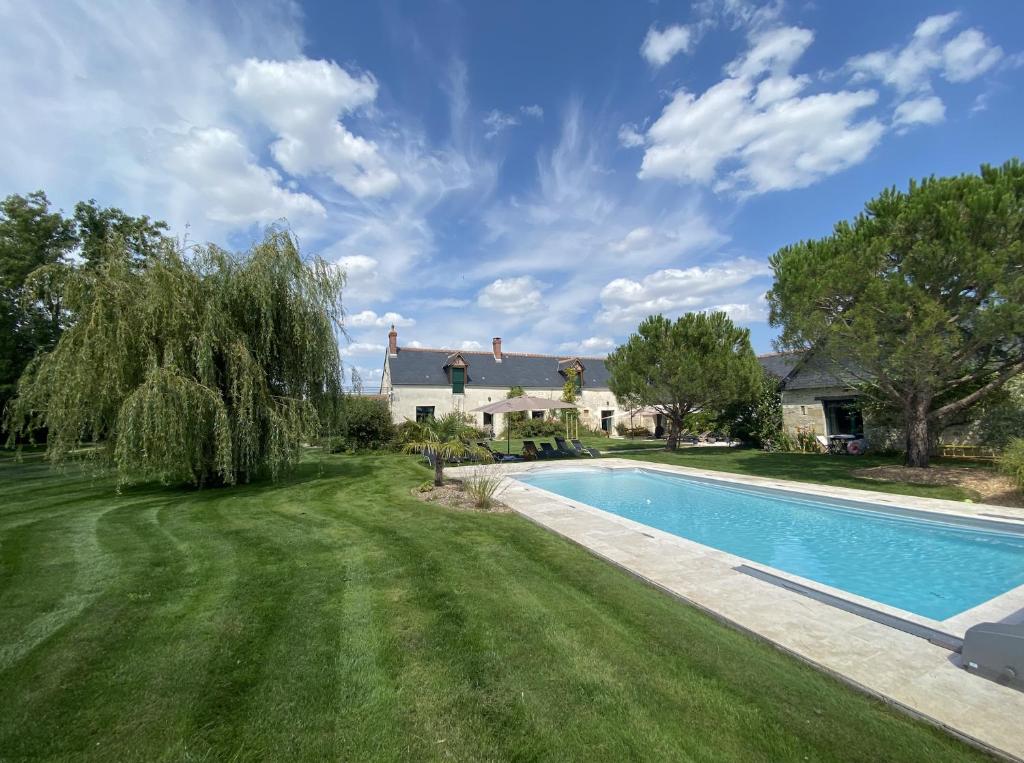 een landgoed met een zwembad en een huis bij FERME DE L'EREAU in Louans