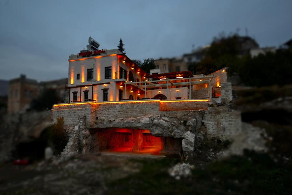 Un modèle de maison avec des lumières rouges sur elle dans l'établissement TÜRKMEN KONAGI HALFETİ BUTİK OTEL, à Halfeti