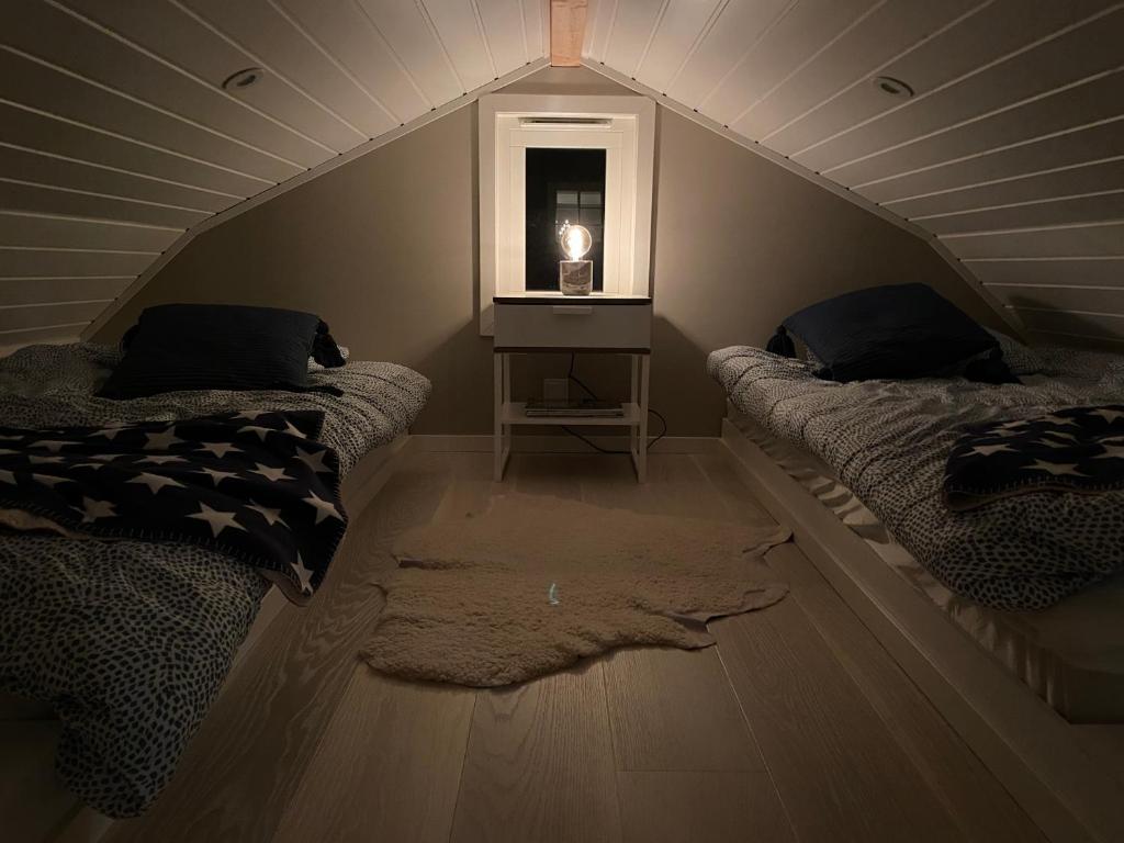 a attic room with two beds and a window at Attefallshus på Ängö i Kalmar in Kalmar
