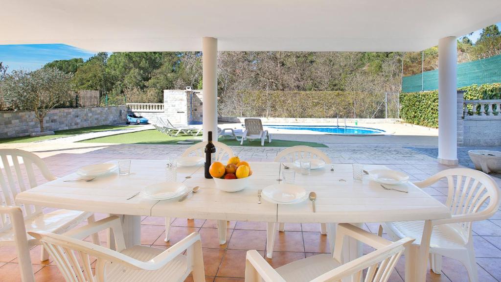 una mesa blanca con un bol de fruta en ella en Villa Brisa - Lloret de Mar, en Mont Barbat