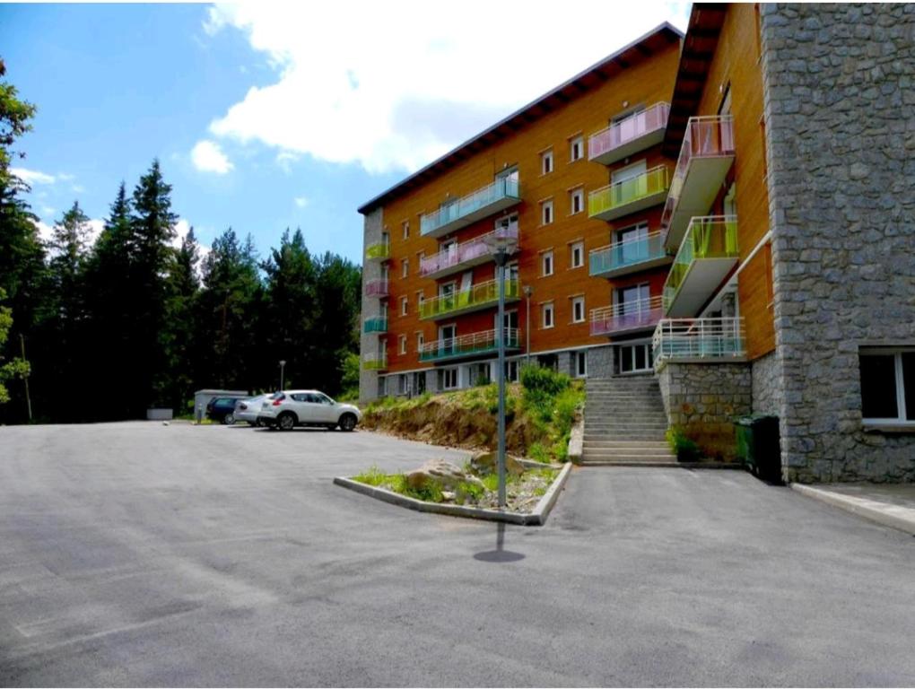 豐羅默奧代洛維亞的住宿－superbe apart vue panoramique sur les pyrénées,balcon plein sud，停车场在有车的大楼前