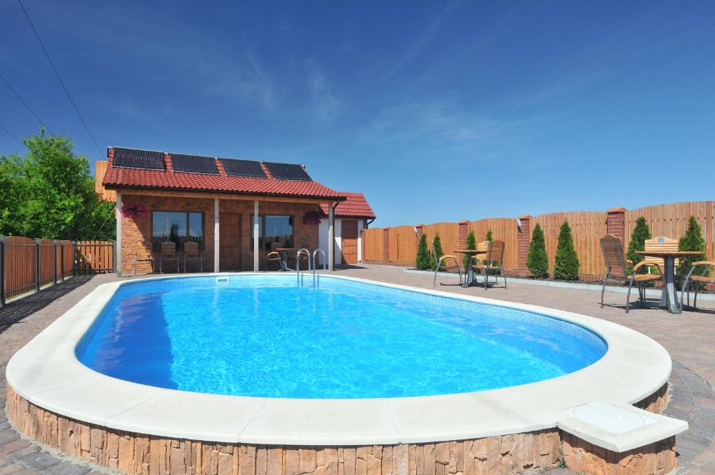 uma grande piscina azul com uma casa ao fundo em Dom Gościnny Ola em Darłowo