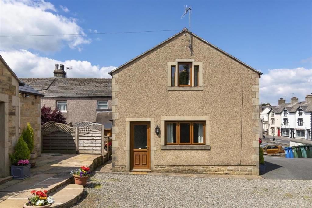 a brick house with a brown door on a street at Rosebank Cottage in Lancaster