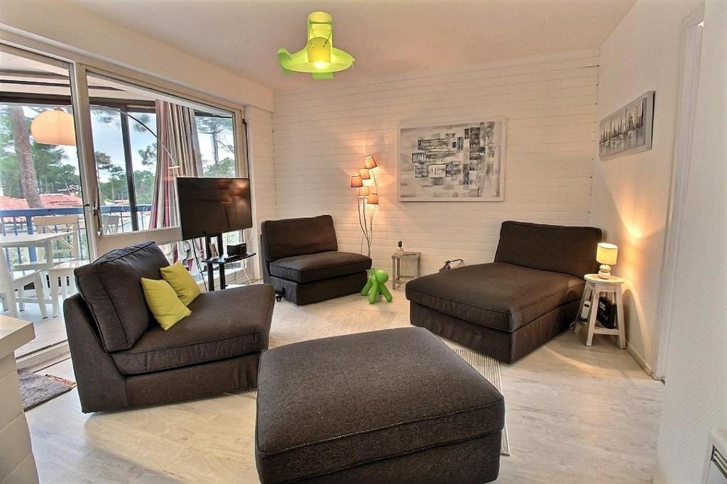 un salon avec deux canapés et une télévision dans l'établissement Cocoon, à Soorts-Hossegor