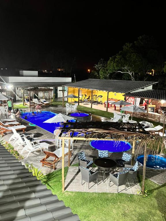 a pool with chairs and umbrellas at night at Pousada dos Duques in Prado