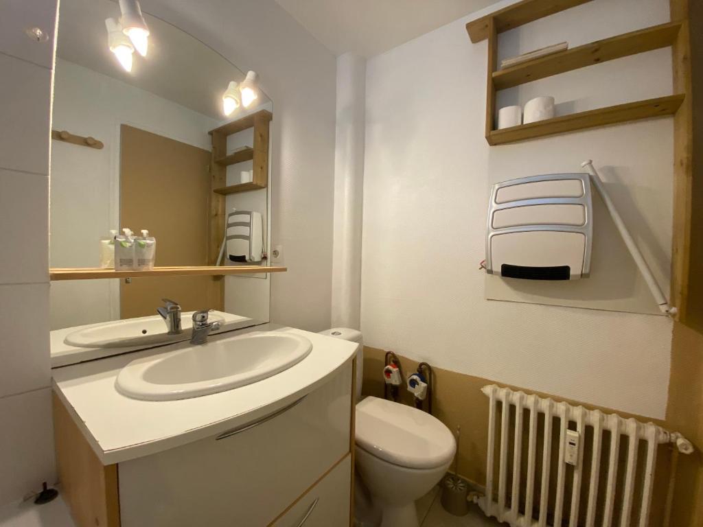 une salle de bain avec un lavabo blanc et des toilettes dans l'établissement Le Campulley - 011, à Rouen