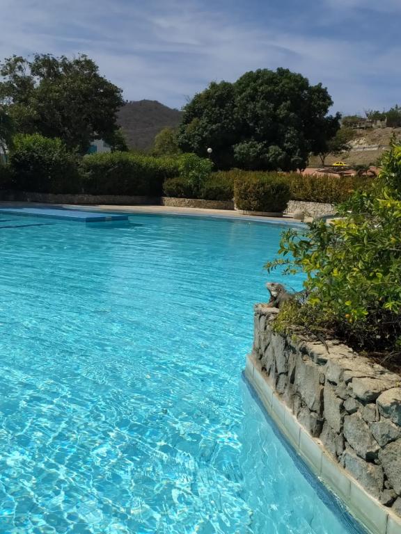 een zwembad met blauw water bij Chalet Condominio Campestre Rodadero Santa Marta wifi Piscina Amplia in Santa Marta