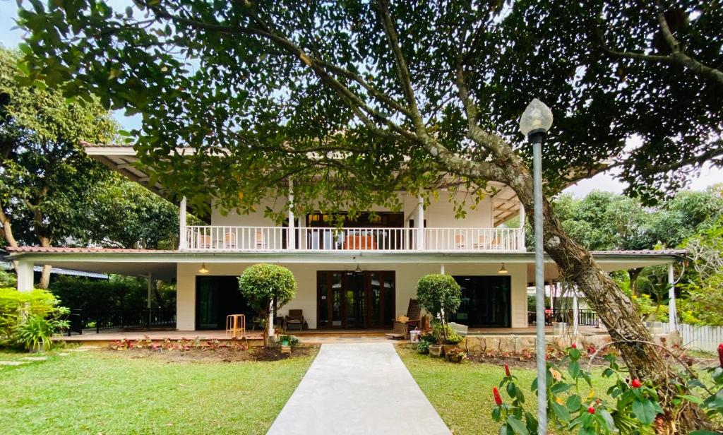 a large white house with a balcony on top of it at Jardin De Mangue Pakchong in Pak Chong