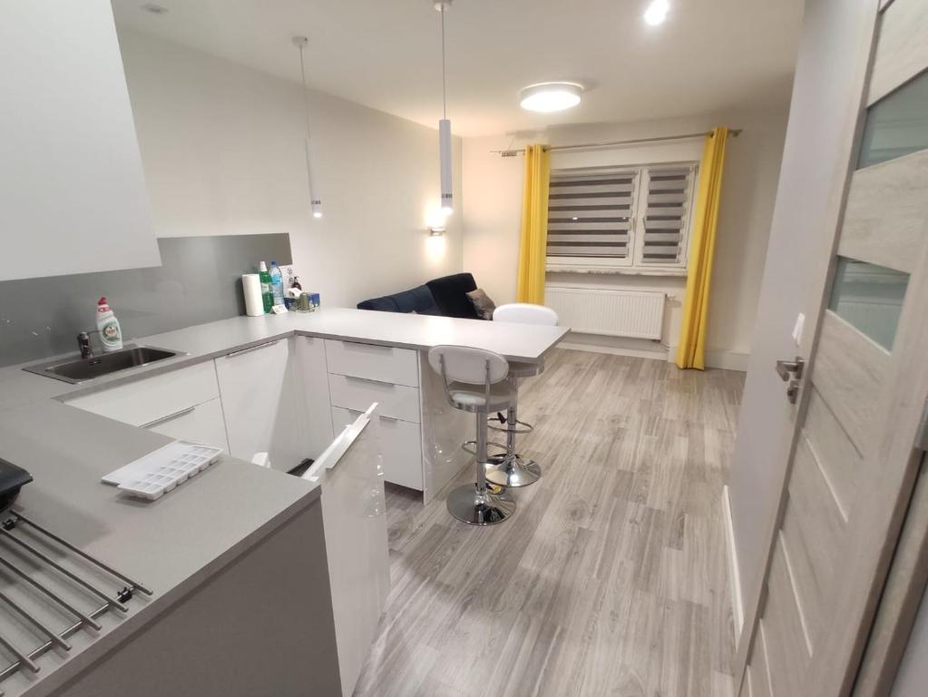 a kitchen with white cabinets and a table and a chair at Comfortable Studio only 20 minutes from International Conference Center Katowice best place for WUF2022 EEC TNF OFF etc in Siemianowice Śląskie