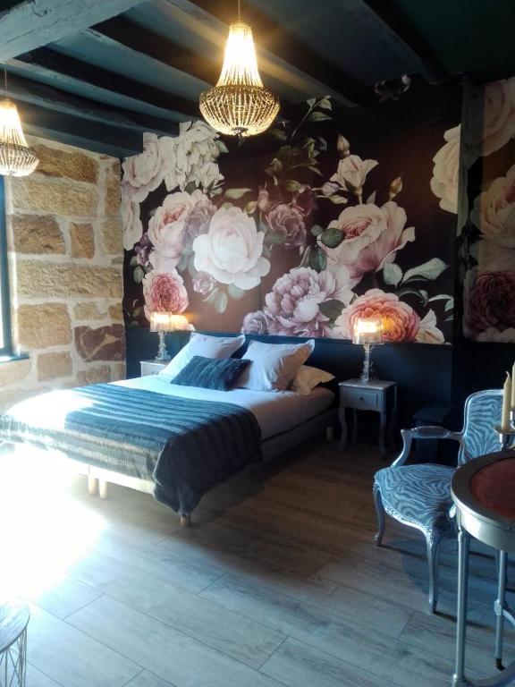 - une chambre avec un lit orné d'un mur fleuri dans l'établissement Au gré du Lot, à Le Bourg