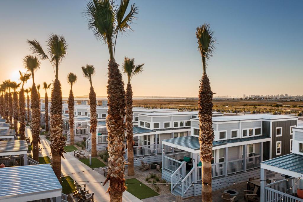 een rij palmbomen voor een gebouw bij Sun Outdoors San Diego Bay in Chula Vista