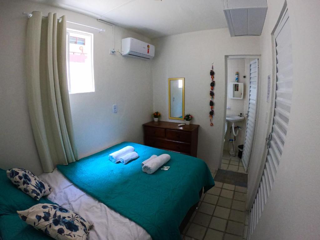 a bedroom with a bed with two towels on it at Porto Paraiso Hostel in Porto De Galinhas