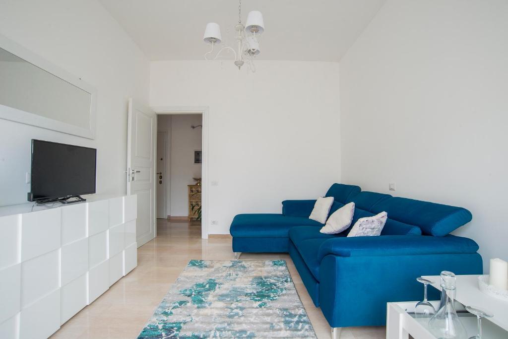 un soggiorno con divano blu e TV di A Casa di Ale a Roma