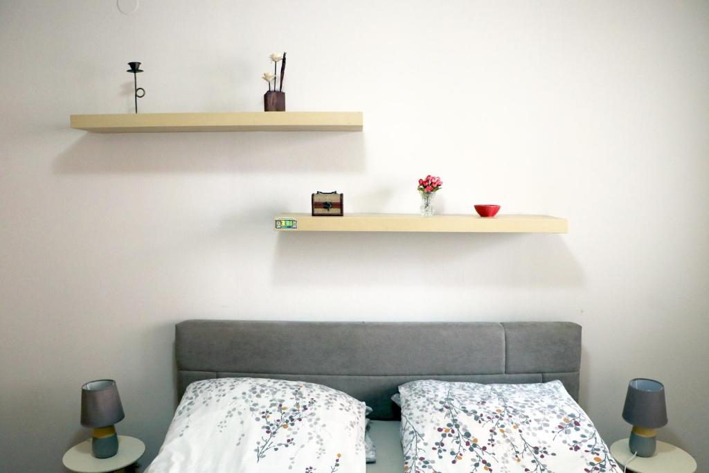 a bedroom with a bed and a shelf on the wall at Spacious modern apartment Aerodrom in Skopje