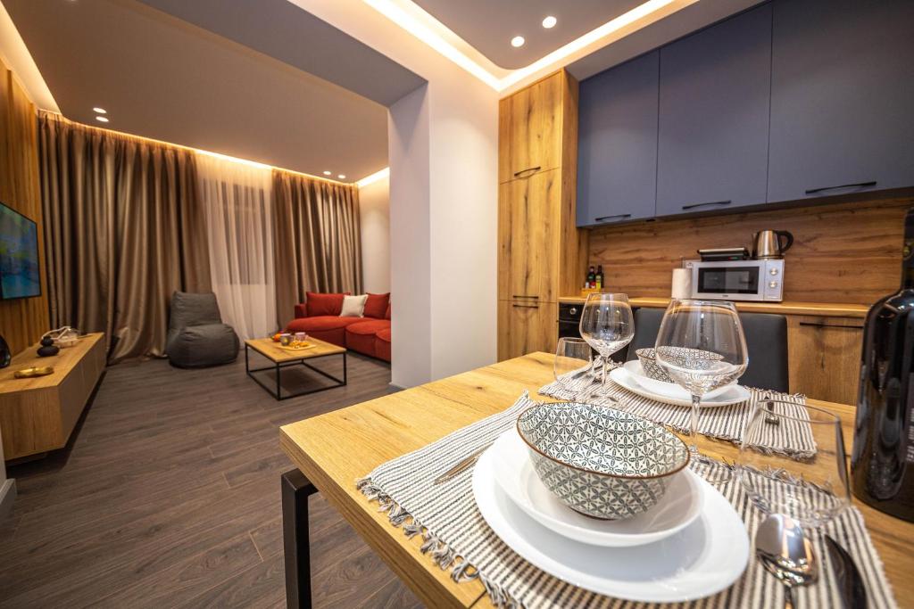 een keuken en een woonkamer met een tafel met wijnglazen bij Blloku Unique Apartments in Tirana